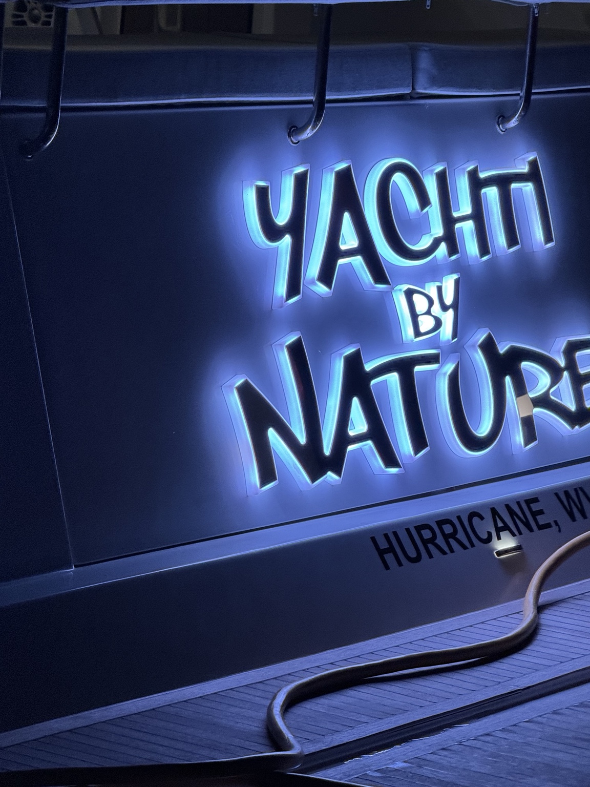 Yachti By Nature illuminated stern logo at night